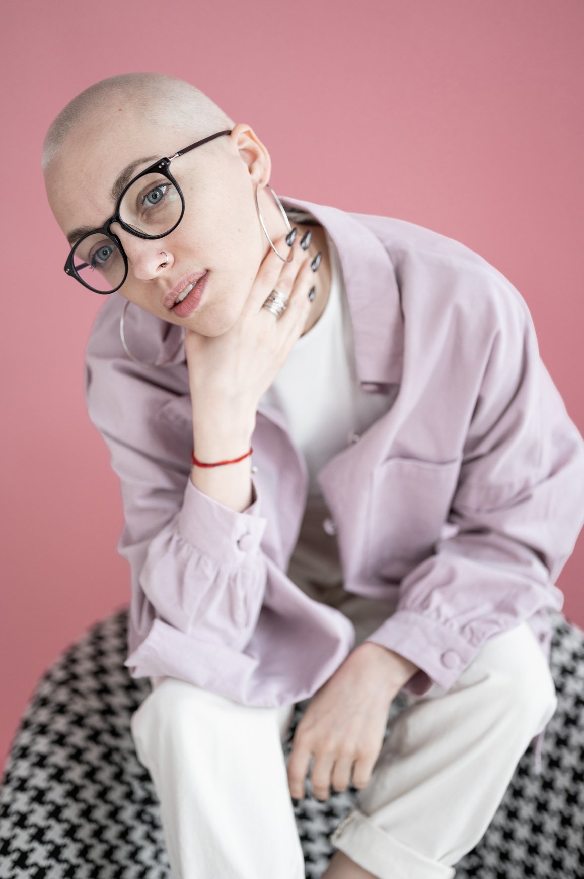 Woman with short blond hair in trendy clothes sitting in studio